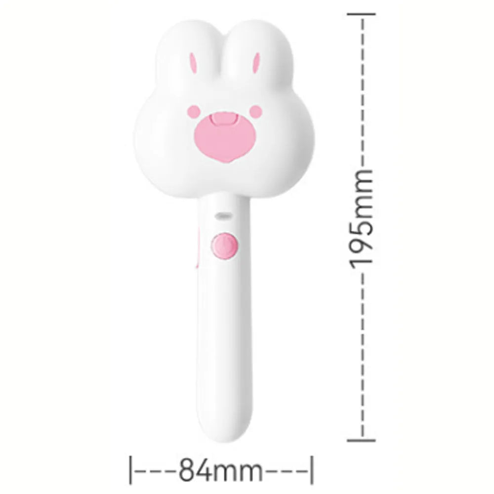 Rechargeable pink cartoon-design steam brush comb for grooming cats and dogs on a table.