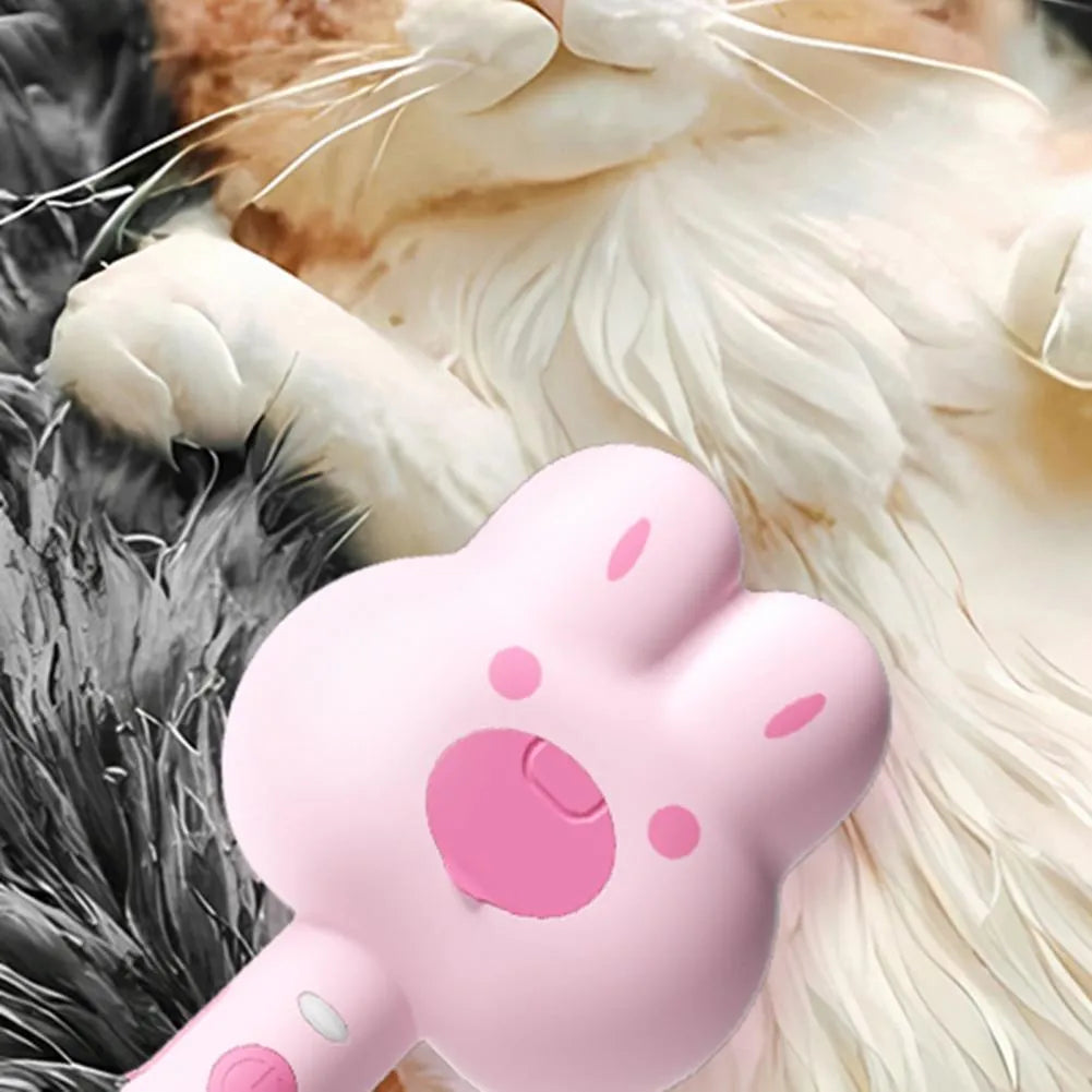 Rechargeable pink cartoon-design steam brush comb for grooming cats and dogs on a table.