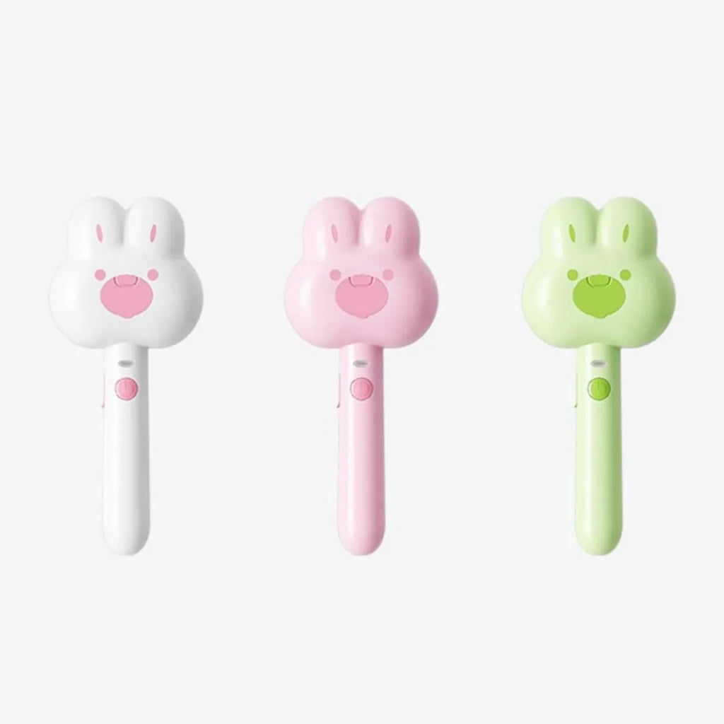 Rechargeable pink cartoon-design steam brush comb for grooming cats and dogs on a table.