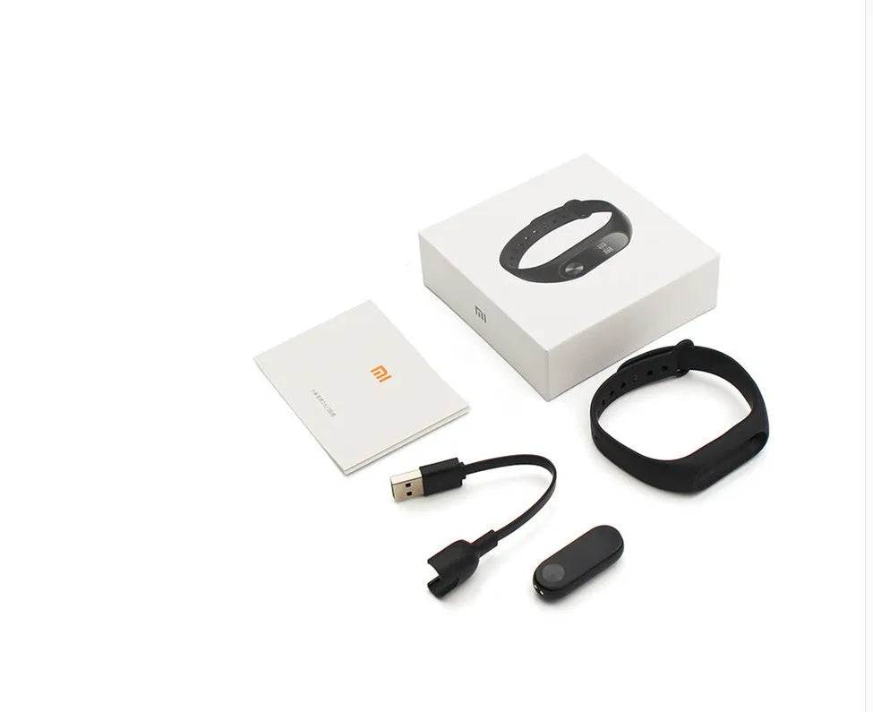 Black Xiaomi Mi Band 2 fitness tracker on wrist showing OLED screen with heart rate data.