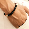 Natural stone beaded bracelet with lava stones on a wrist, showing ethnic style and unisex design.