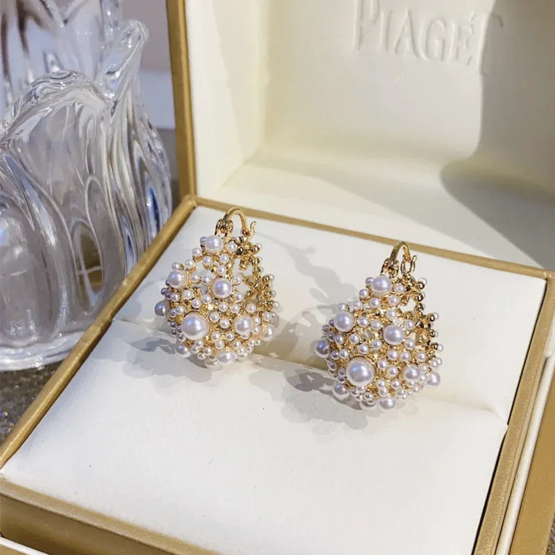 Gold coloured women's flower basket earrings with pearl inlay and small rice-shaped bead details.