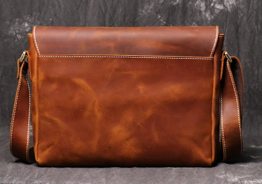 Vintage brown leather mens messenger bag with a flap opening and adjustable shoulder strap.
