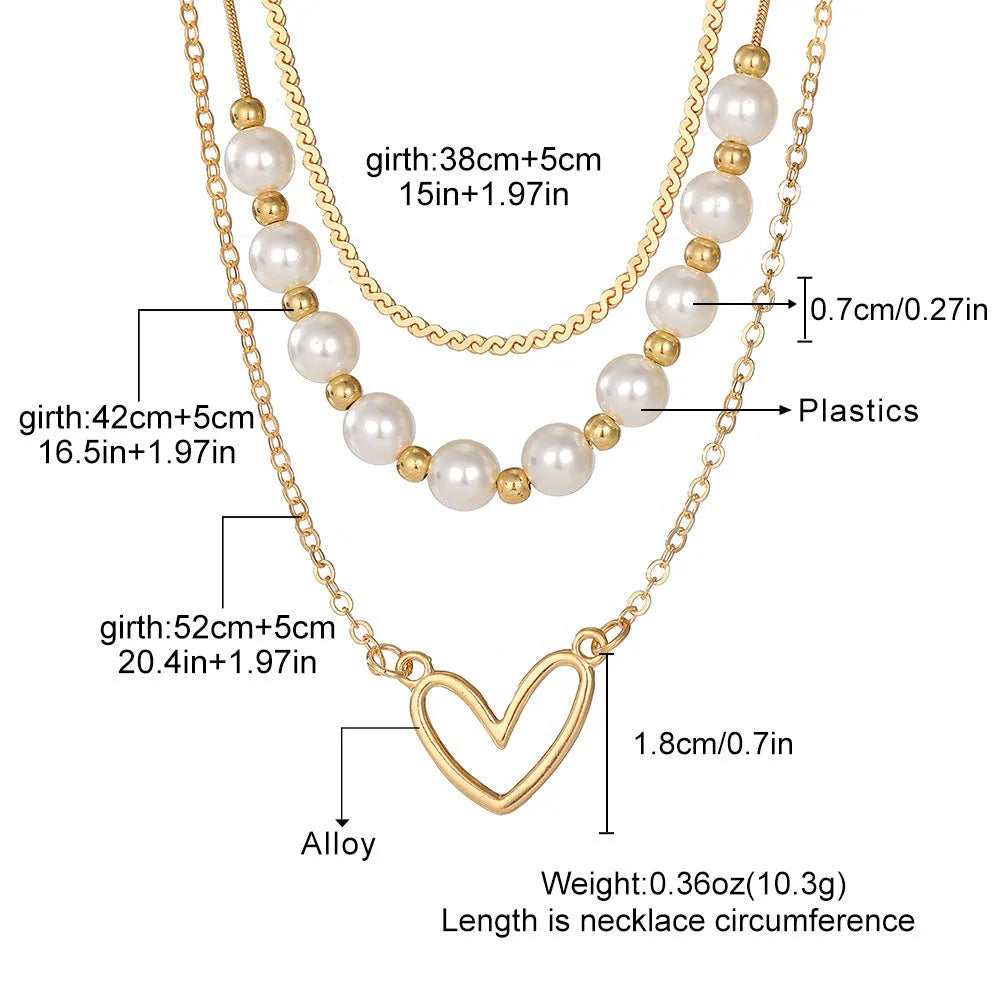 Vintage gold necklace with love heart pendant on a pearl chain, adjustable length.