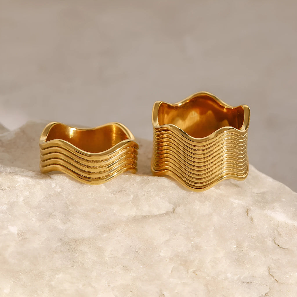 Stainless steel wide band ring with a geometric wave pattern, shown in silver and gold electroplated finishes.
