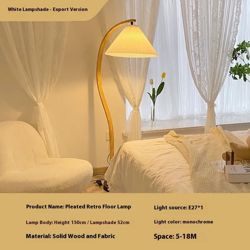 Retro-style vertical table lamp with log white lampshade placed on a sofa arm.