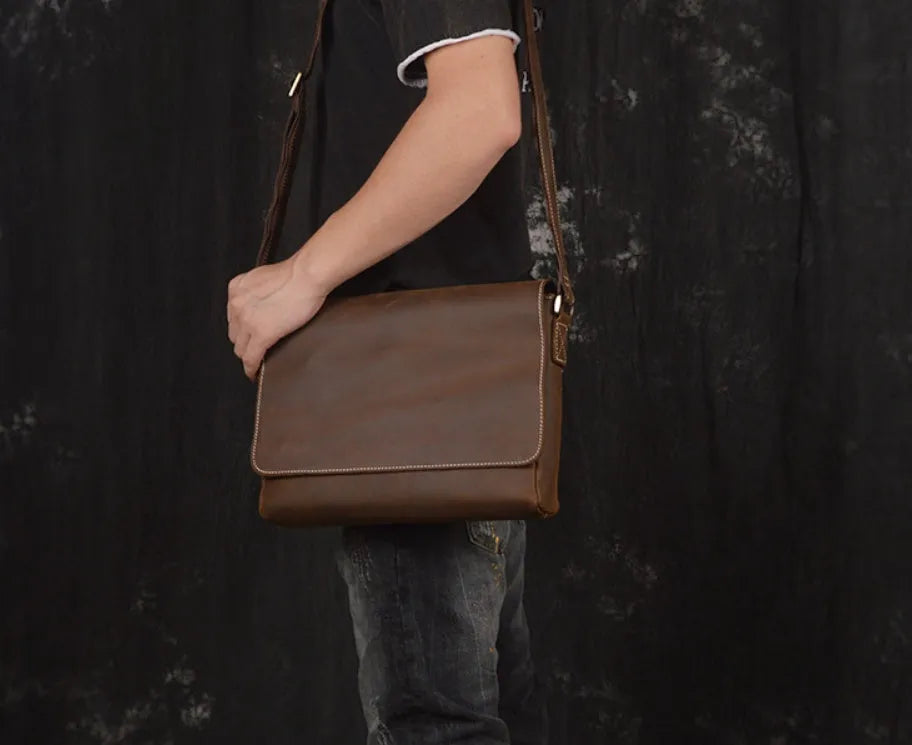 Vintage brown leather mens messenger bag with a flap opening and adjustable shoulder strap.