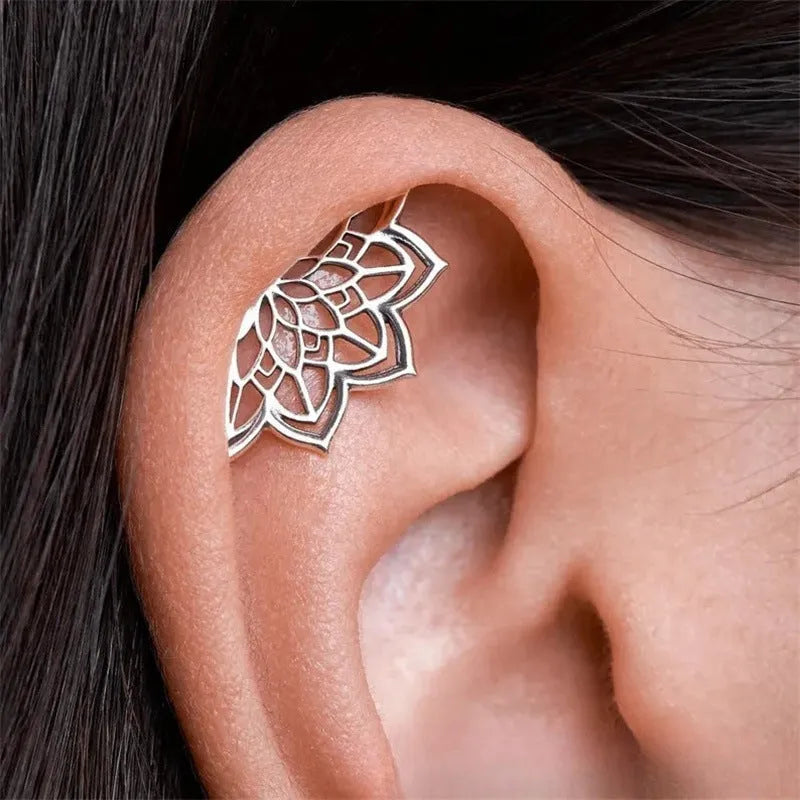 Close-up of metal spider web geometric mesh design stud earrings in a gold electroplated finish.