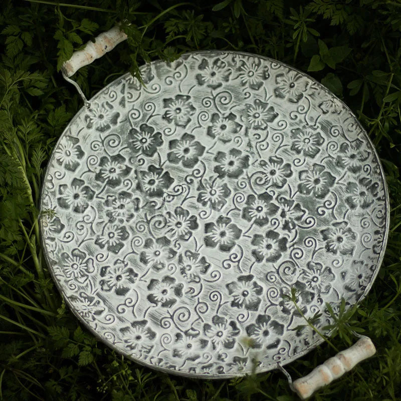 Round wrought iron storage tray in two sizes on a wooden surface.