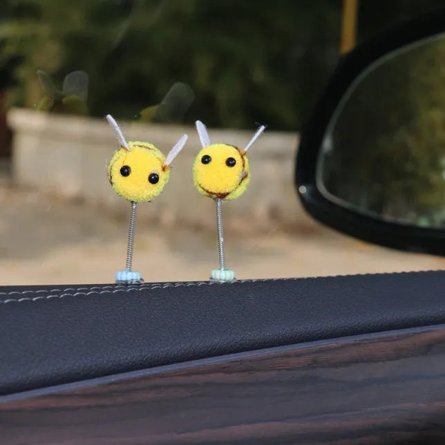 Small plush swing spring bee car decoration ornament on a 3cm scale grid.