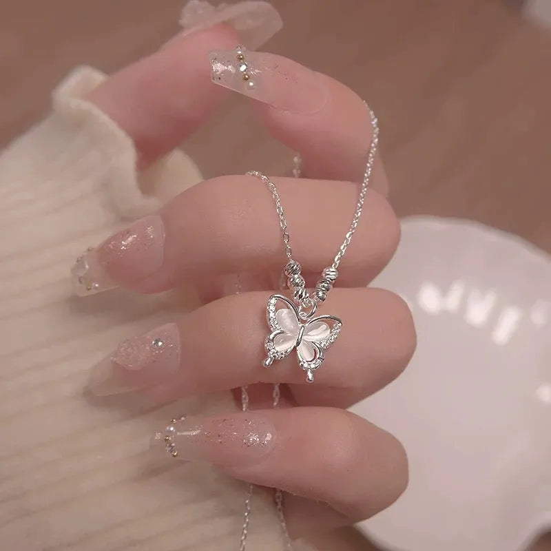 Close-up of a women's square line opal butterfly pendant on a silver adjustable cross chain necklace.