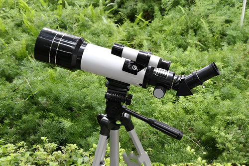 Dark blue children's monocular astronomical telescope with adjustable tripod set up for stargazing.