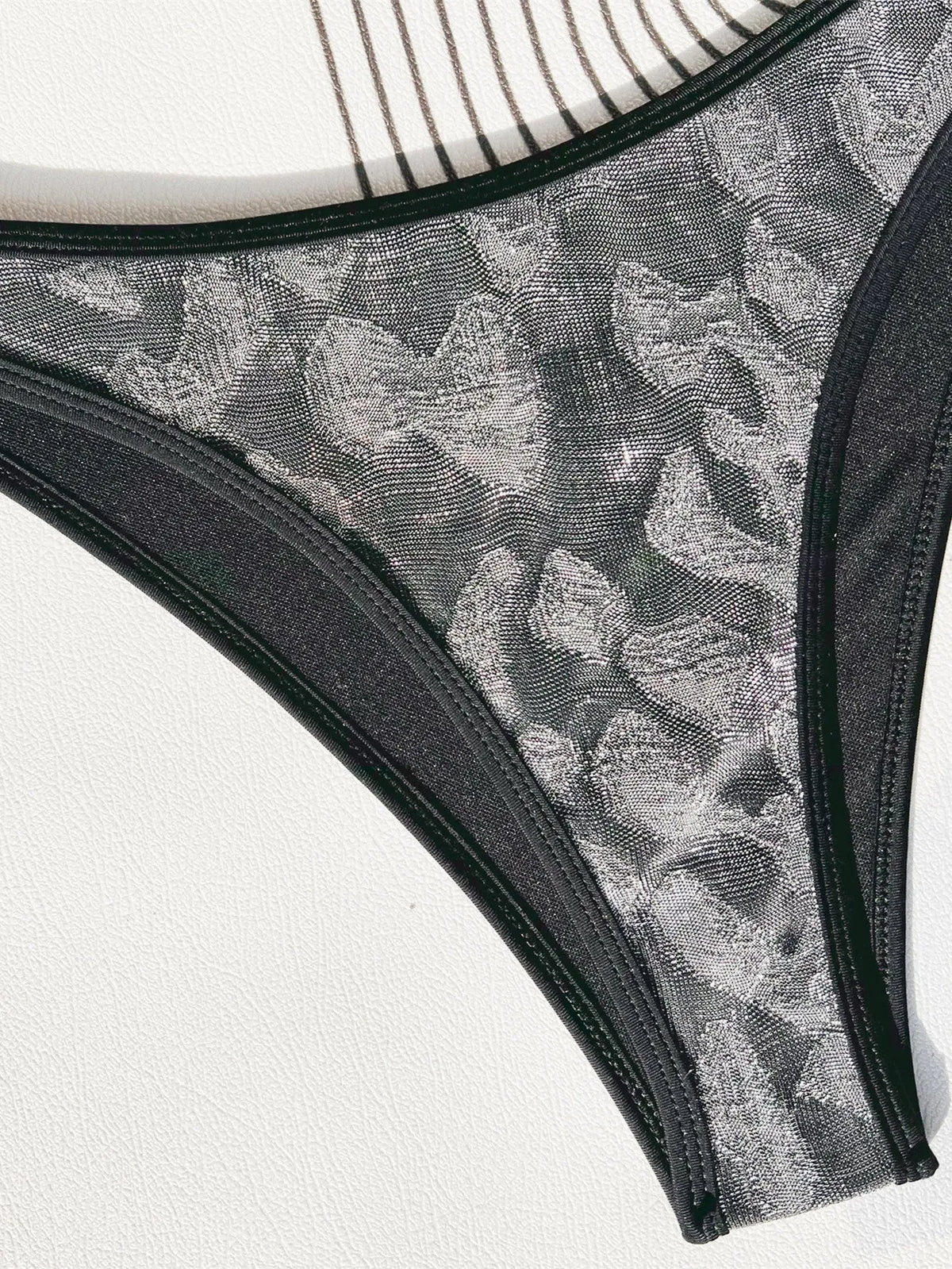 Ladies black polyester bikini swimsuit with strap design on a mannequin.
