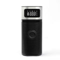 Black portable wireless air pump with digital display, LED light, and attached inflation tube on a textured surface.