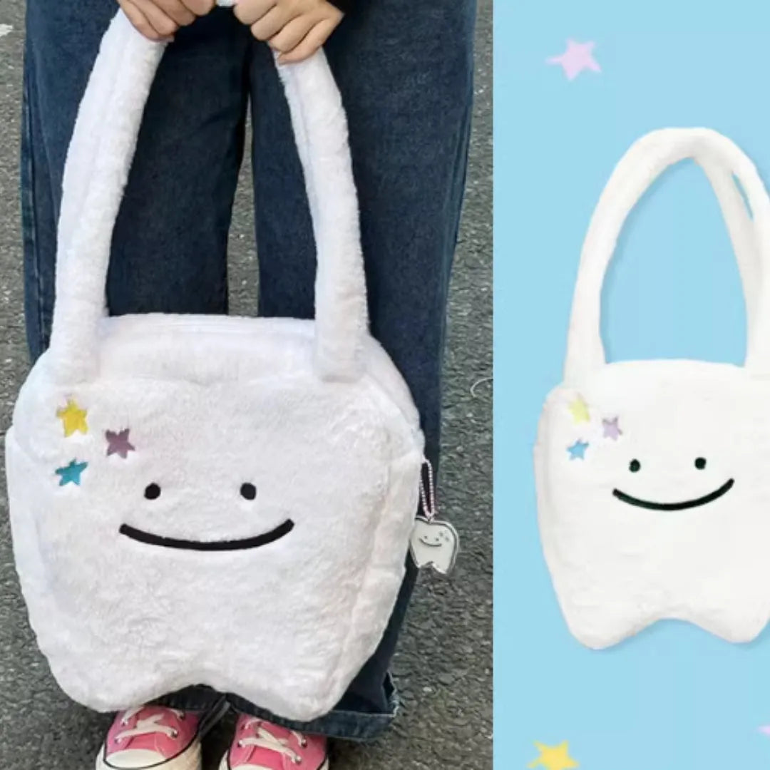 White plush tote bag with a cute teeth pattern, showing the shoulder strap and zipper closure