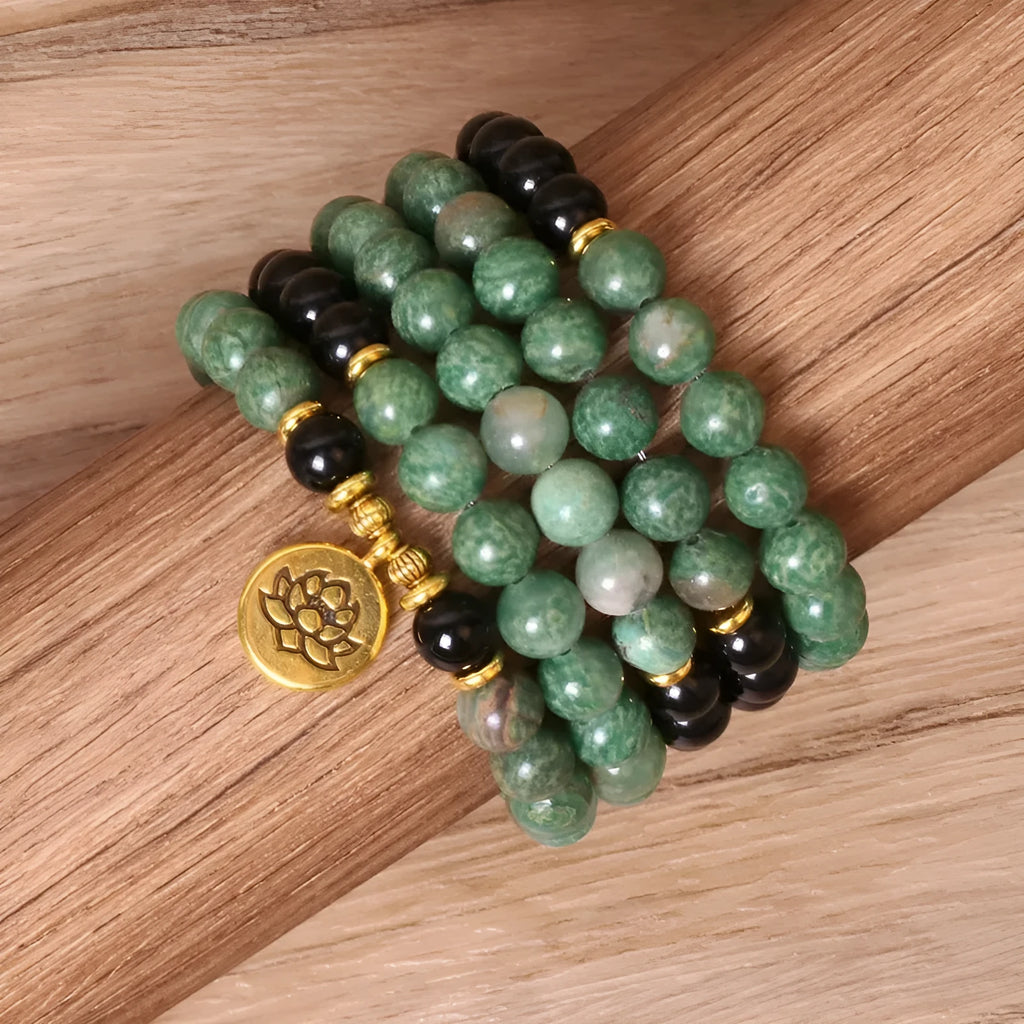Green and black alloy bead elastic bracelet stretched on a wrist.