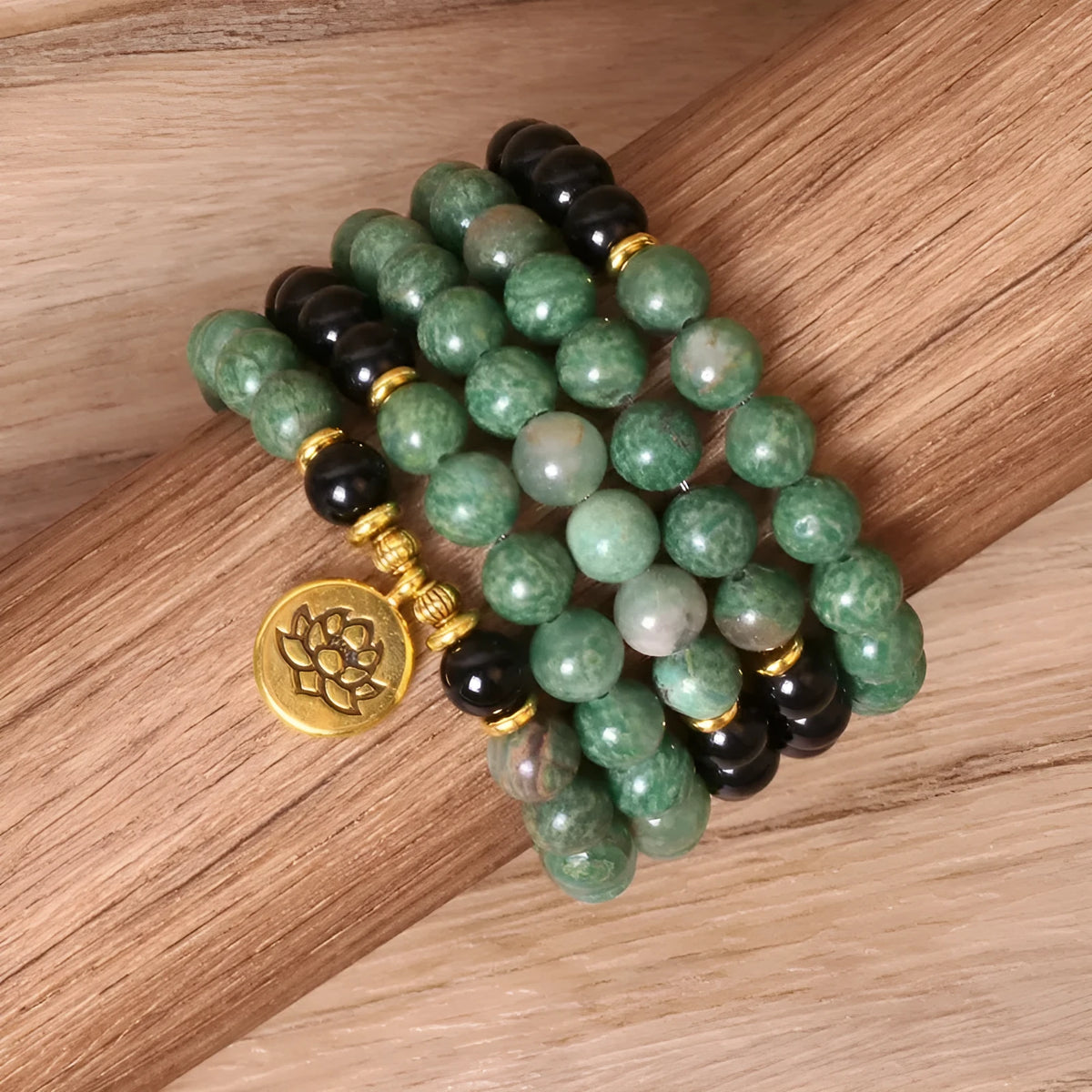 Green and black alloy bead elastic bracelet stretched on a wrist.