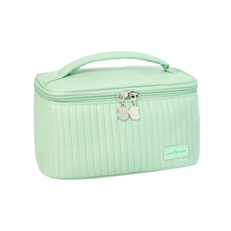 Open-top cake-shaped makeup bag in PU leather shown in a light colour, demonstrating its structured shape and easy-access design.