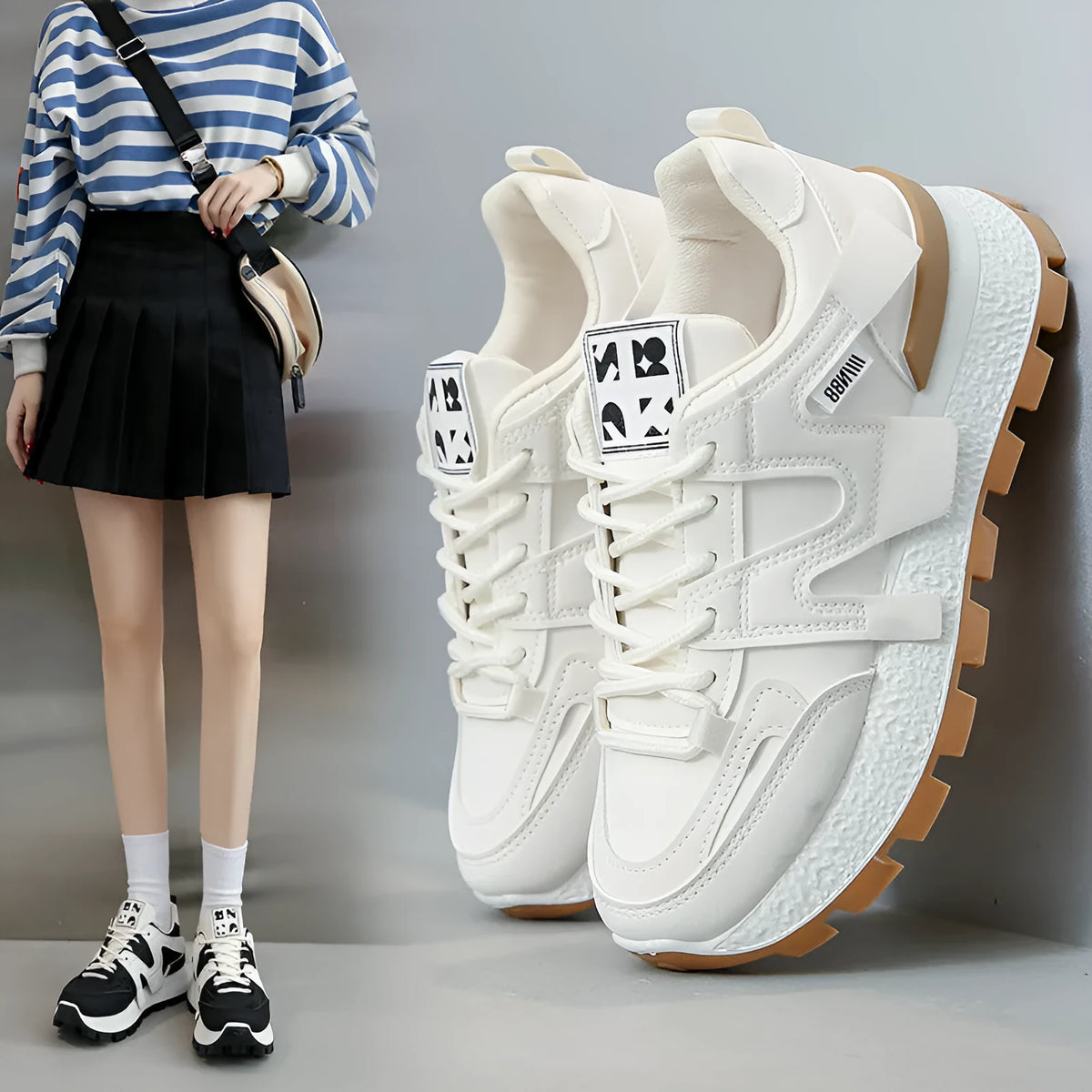 Low-top round-toe sneaker in black or white with lace-up front and flat rubber sole.