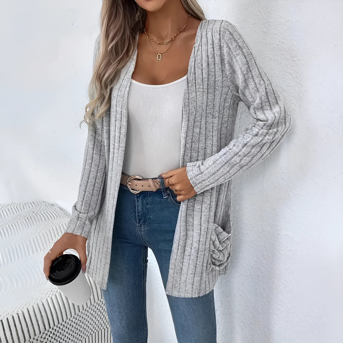 Loose fit grey cardigan with long sleeves and side pockets on a hanger.