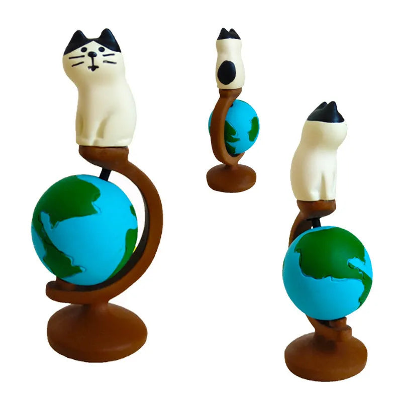 Cartoon cat dressed as Statue of Liberty resin craft figurine on desk.