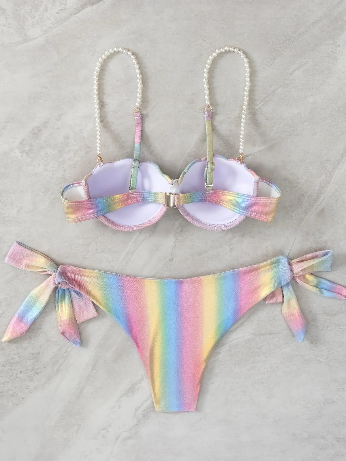 Rainbow coloured women's bikini swimsuit with split tied design on a mannequin