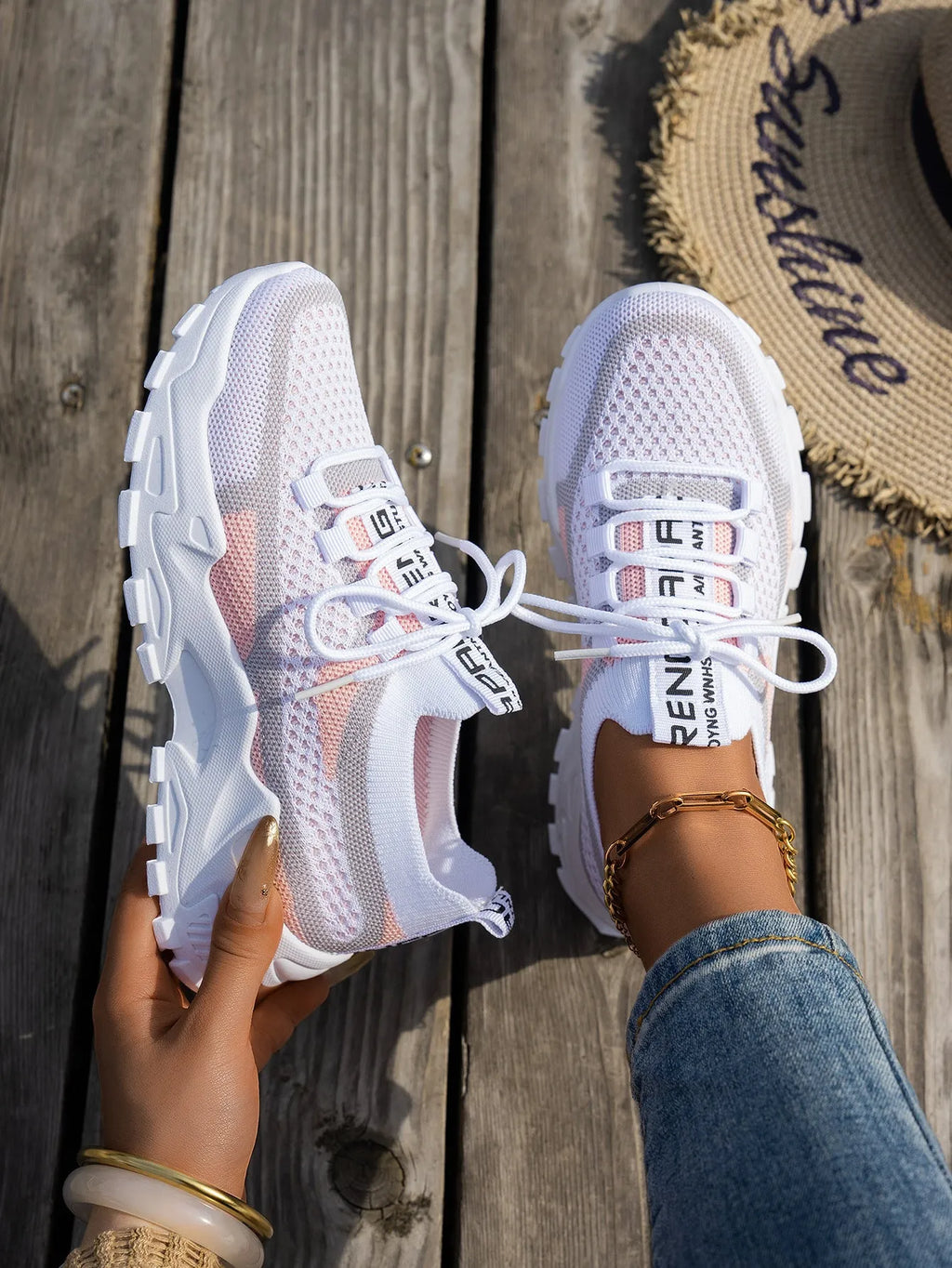 Women's Flyknit mesh sneakers in grey and white with a flat rubber sole and lace-up front.