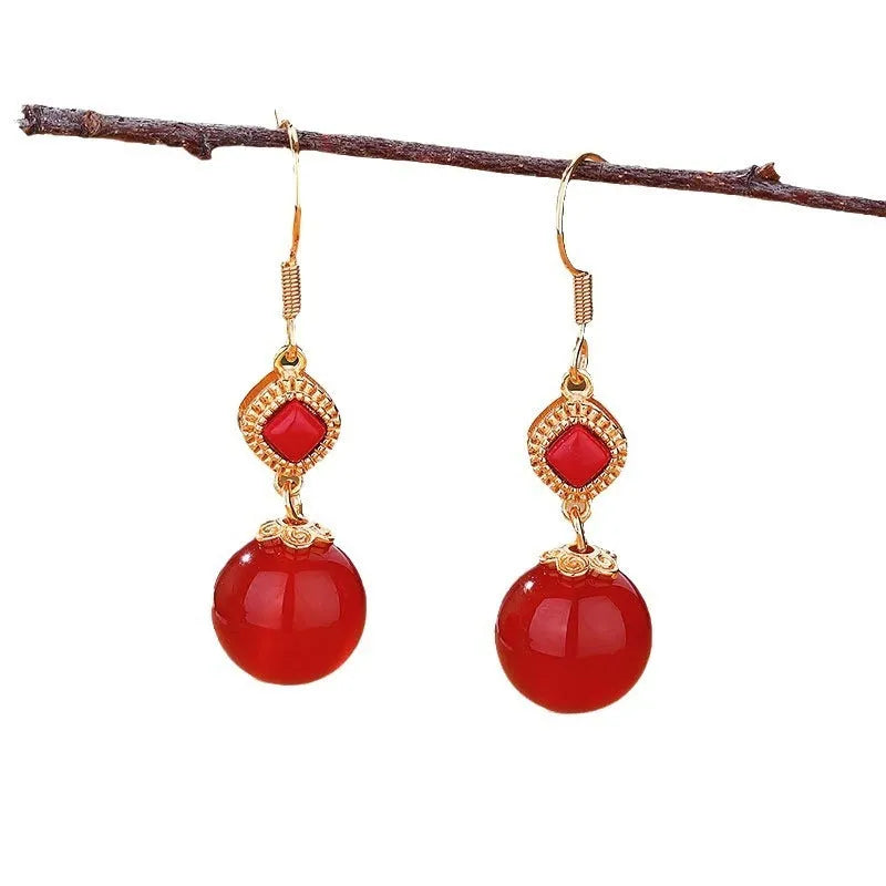Geometric drop earrings with red agate beads, silver settings, and jasper accents on copper alloy