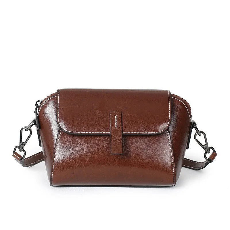 Brown women's genuine leather messenger bag with cross-body strap, showing outer sandwich pocket and visible sewing detail.