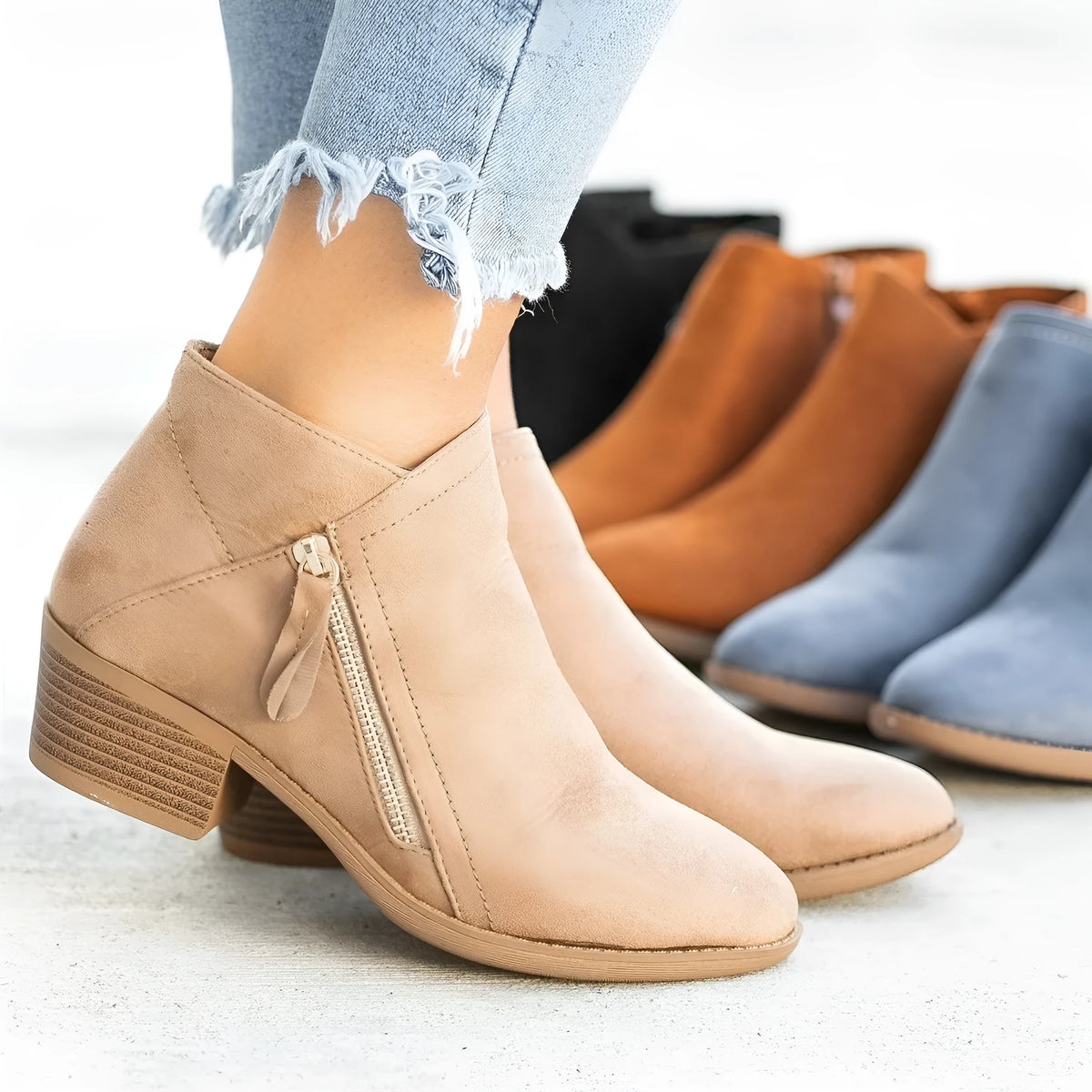 Women's suede ankle boots with a side zip and chunky heel in beige, shown from the side.