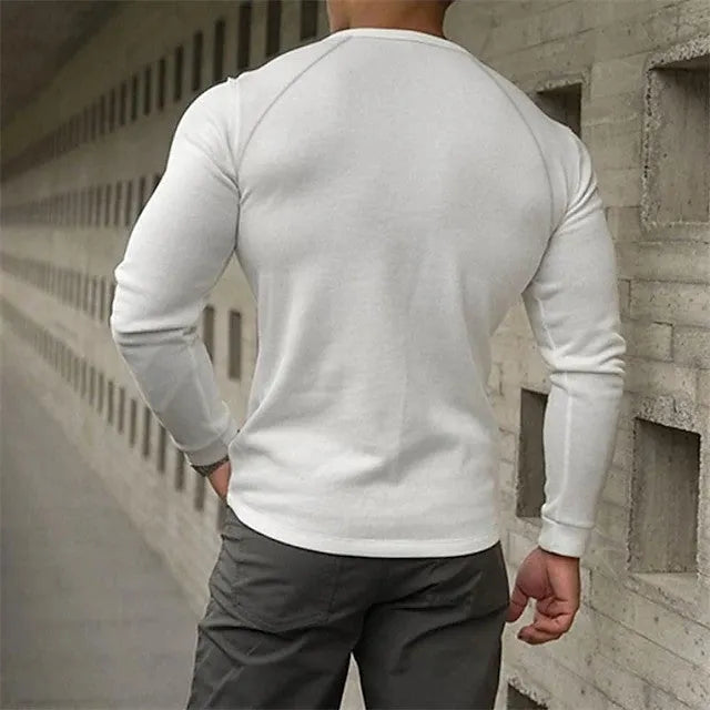 Man wearing a navy blue long-sleeved t-shirt with a Henry collar, showcasing the pullover style.
