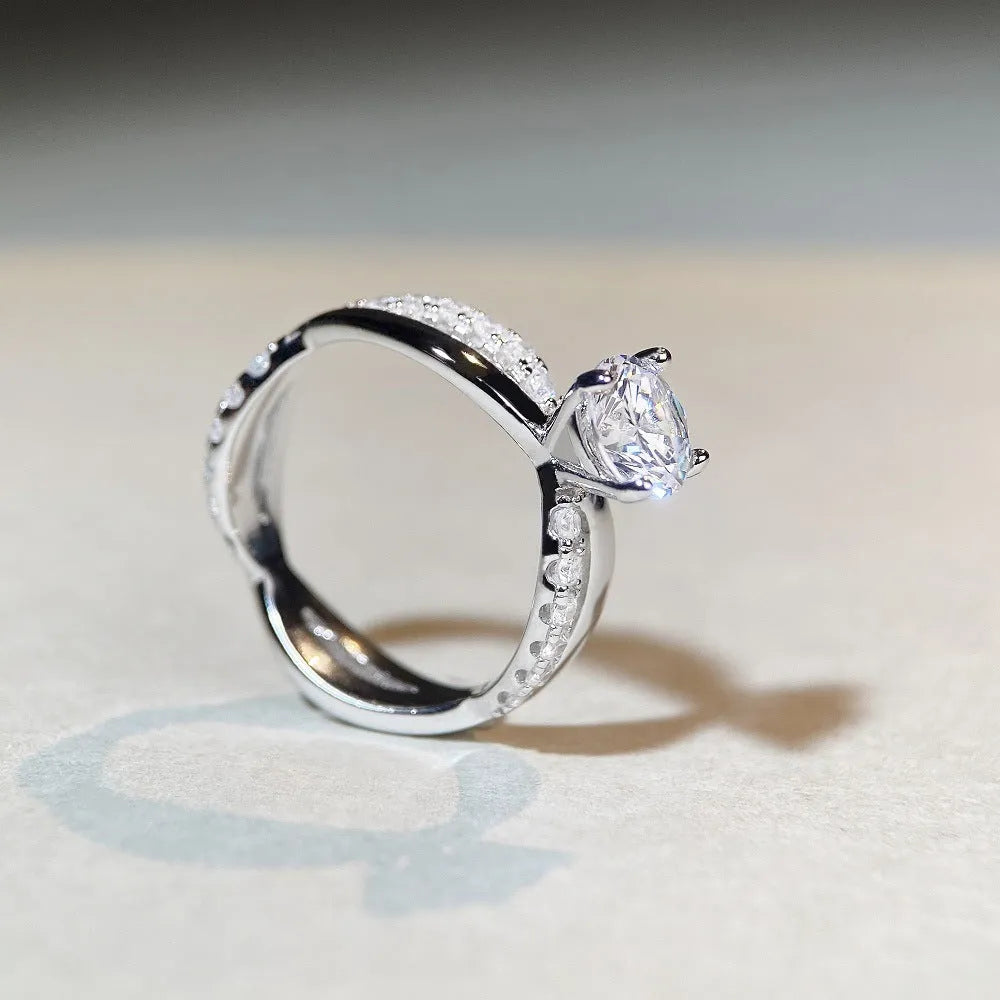 Women's geometric cross moissanite ring with twisted silver band and 1 carat stone.