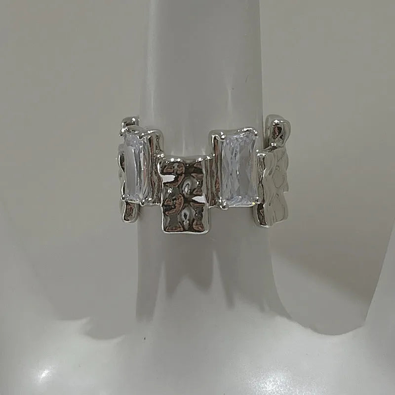 Silver geometric cross ring with open gemstone setting and three-dimensional decoration