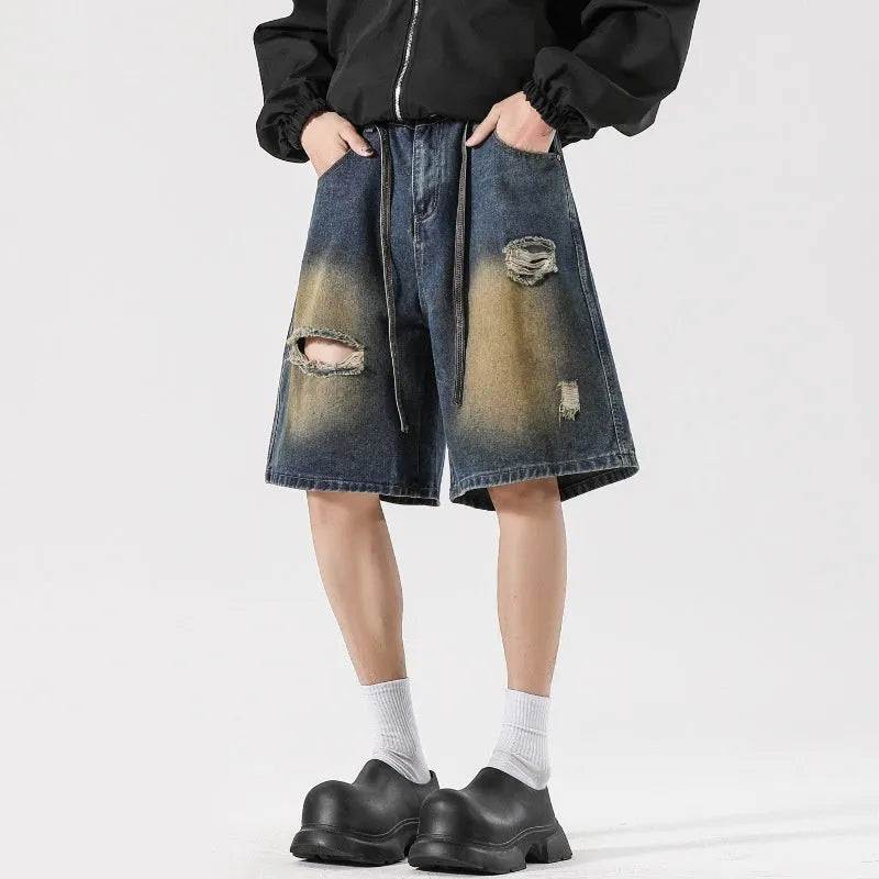 Man's loose-fit ripped jeans in retro blue denim, showing distressed detailing on legs.