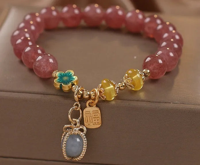 Red women's bracelet with strawberry quartz beads, alloy metal elements, and rhinestone decorative details on adjustable band