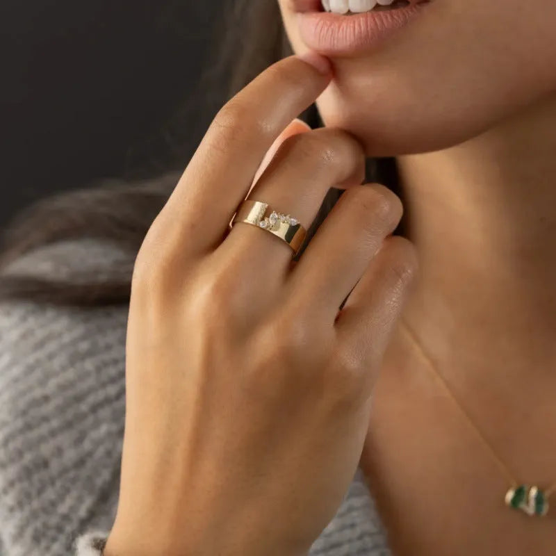 Gold electroplated zircon ring on finger, showing metallic finish and decorative elements