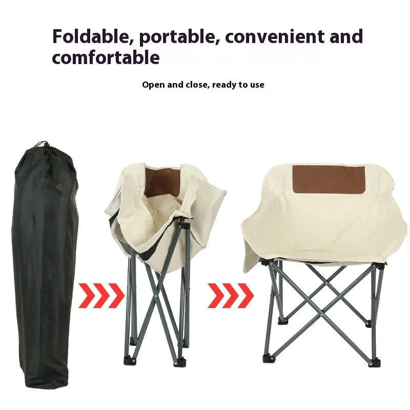 Beige folding camping chair with reclined back and steel frame on grass.