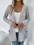 Loose fit grey cardigan with long sleeves and side pockets on a hanger.