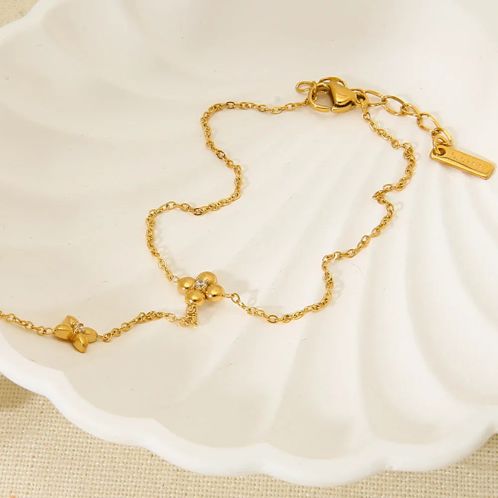 Gold-coloured women's bracelet with floral and eight-pointed star design on stainless steel