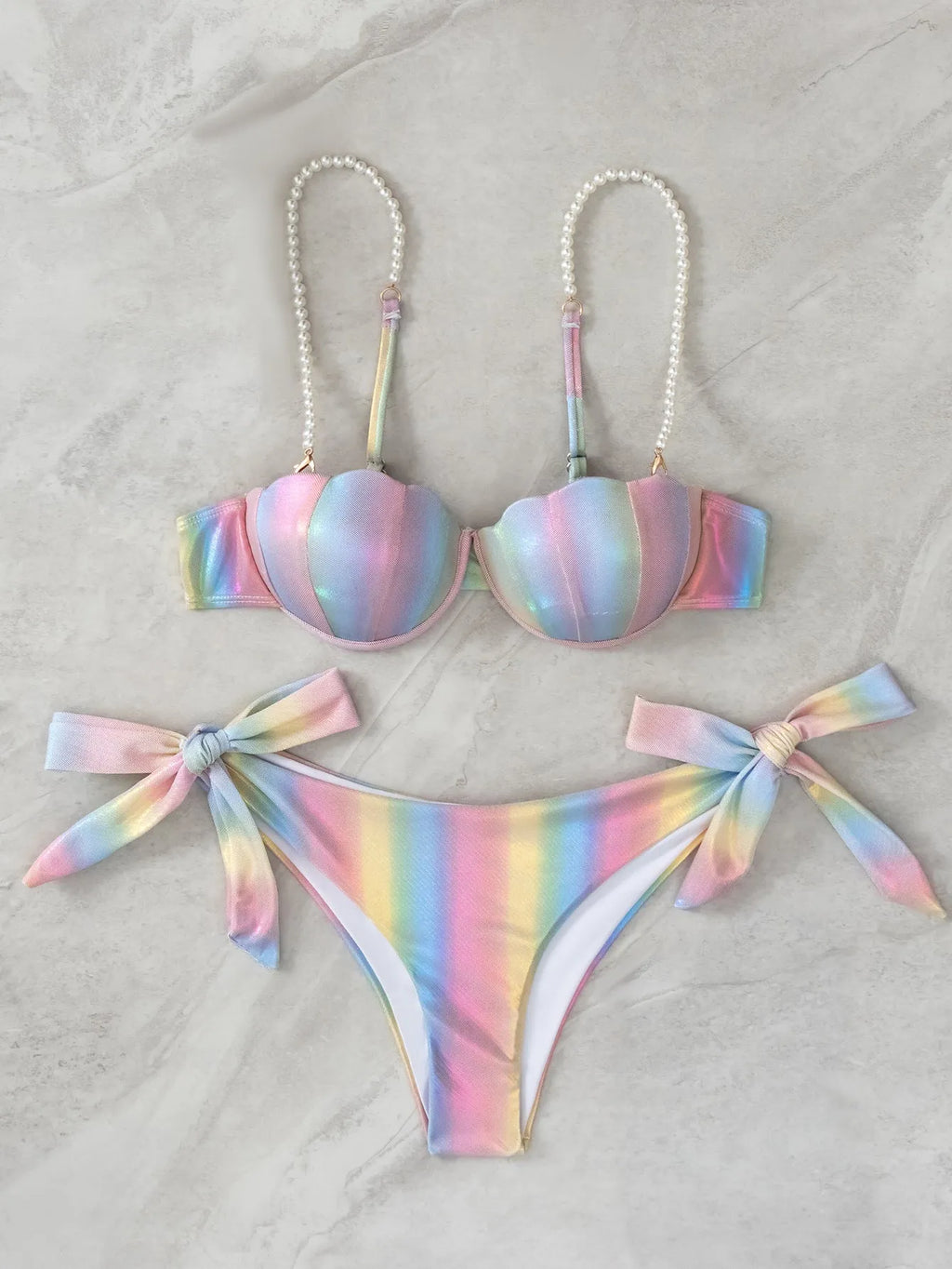 Rainbow coloured women's bikini swimsuit with split tied design on a mannequin