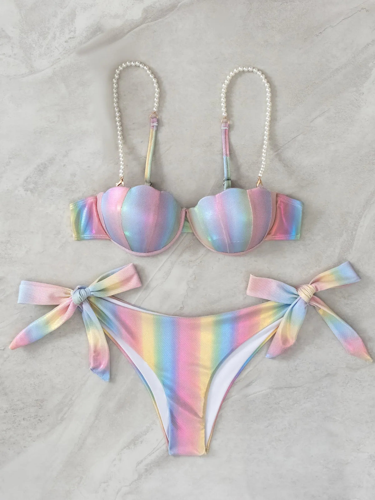 Rainbow coloured women's bikini swimsuit with split tied design on a mannequin