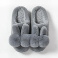 Women's fluffy bunny slippers in creamy white with a high rabbit fur upper and decorative flowers.