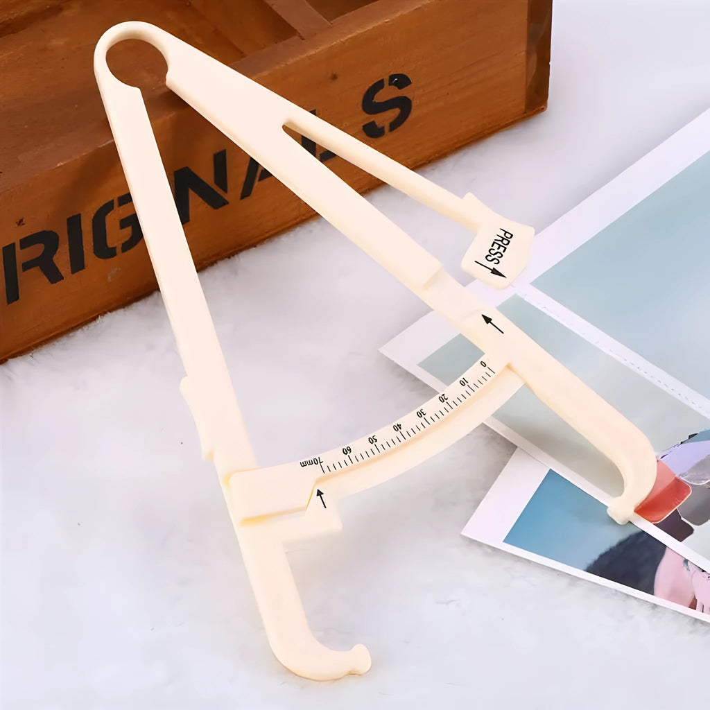 Clear acrylic skin fold fat caliper for body fat measurement showing measurement scale.