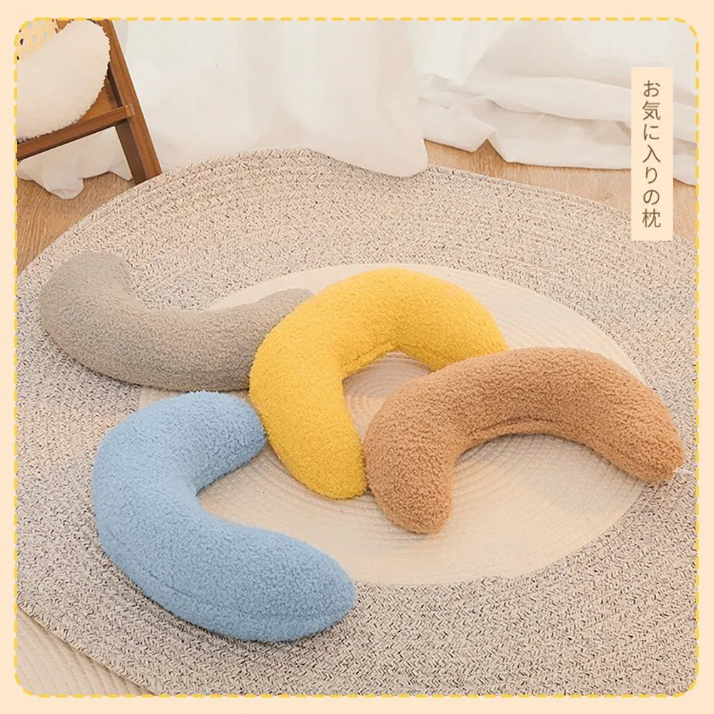 U-shaped blue cat pillow with adjustable fabric collar on a sofa