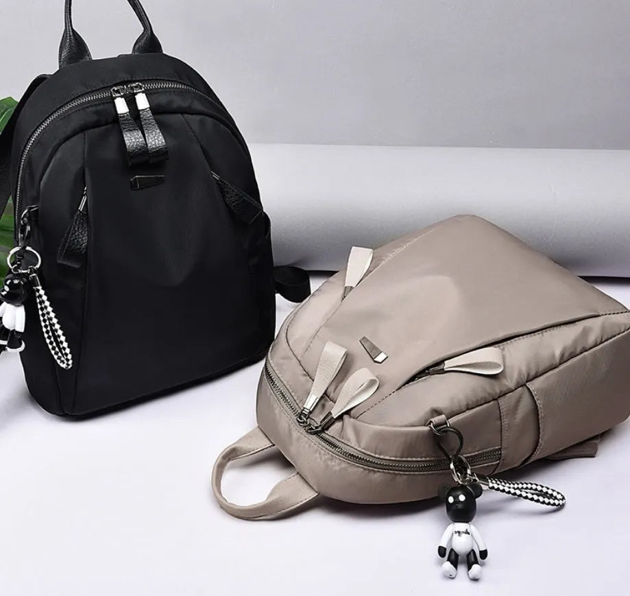 Medium square grey Oxford cloth rucksack with double straps, shown open to reveal internal phone and organiser pockets.