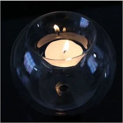 Clear hollow glass spherical candle holder in European style on a table.