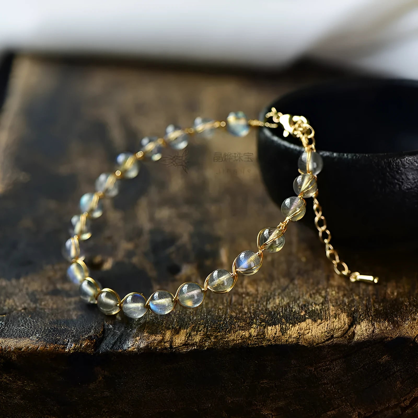 Blue moonstone and gold tone bracelet with 6mm beads on a wrist.