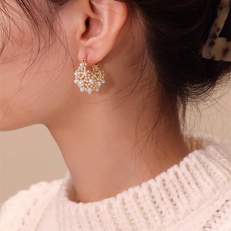 Gold coloured women's flower basket earrings with pearl inlay and small rice-shaped bead details.