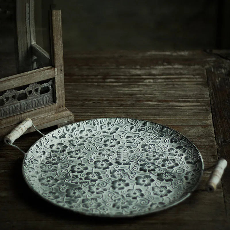 Round wrought iron storage tray in two sizes on a wooden surface.