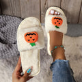 White and yellow pumpkin plush open toe slippers with cartoon Halloween design on synthetic fur